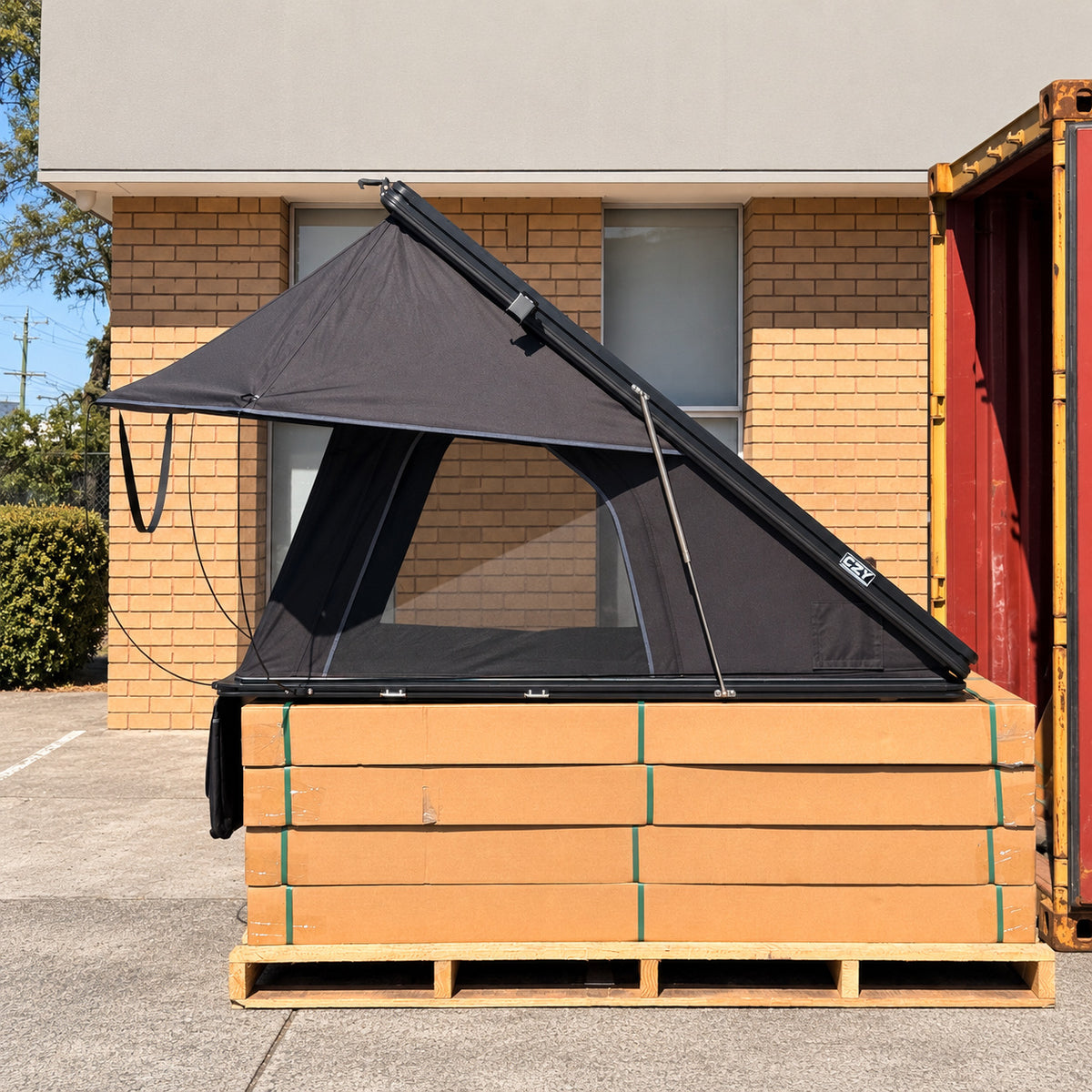 Side view of the open CZY AIR rooftop tent on the original carton display in a clean warehouse forecourt.