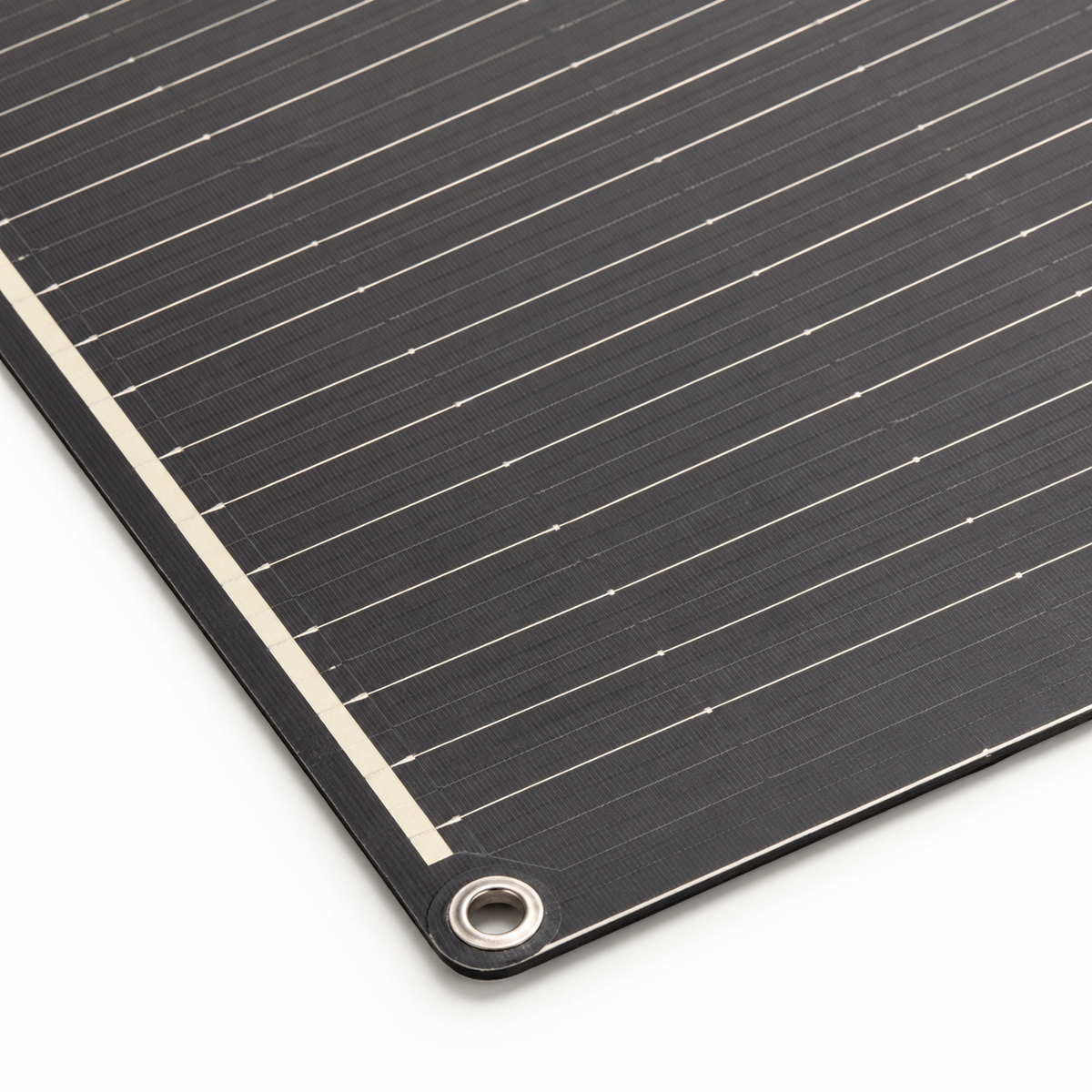 Close-up of a corner eyelet, thin laminate edge and silver conductors on the 200W flexible solar panel.