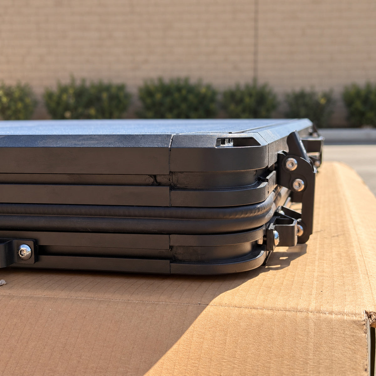 Close-up of the closed CZY AIR shell corner and original fastening hardware on corrugated cardboard.