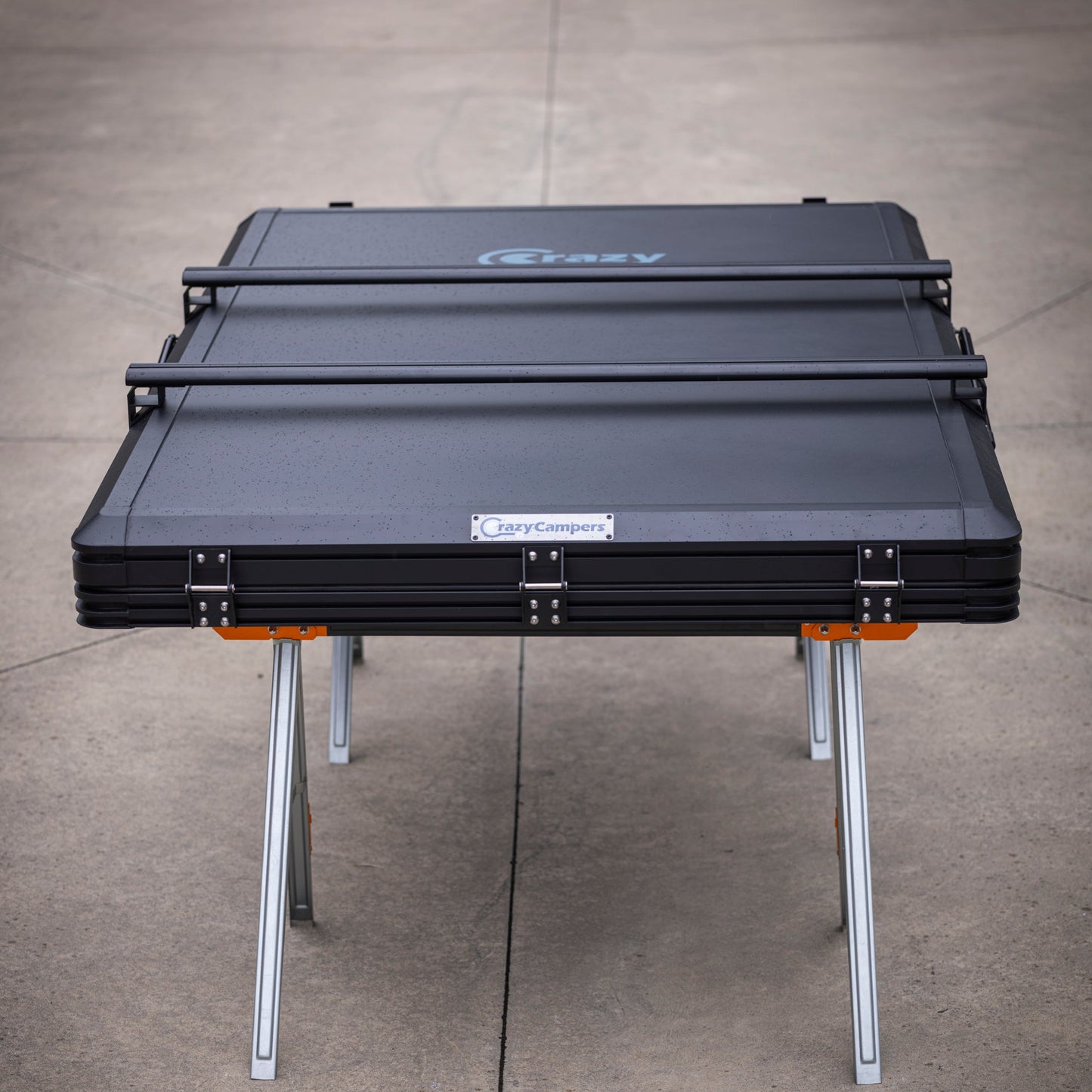 Black CrazyCampers TrailReady 1450 hard shell rooftop tent shown closed on display legs