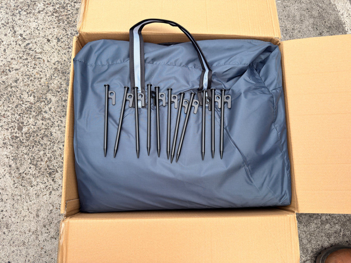 XL 270+ Awning accessory bag and pegs laid out on cardboard