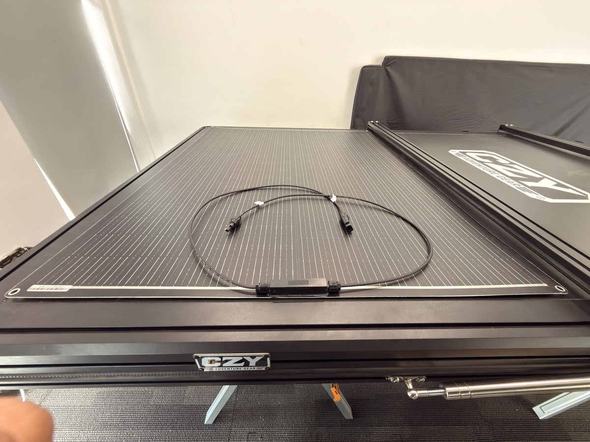 DOKIO 200W flexible solar panel with its integrated connection leads and junction box on a rooftop tent